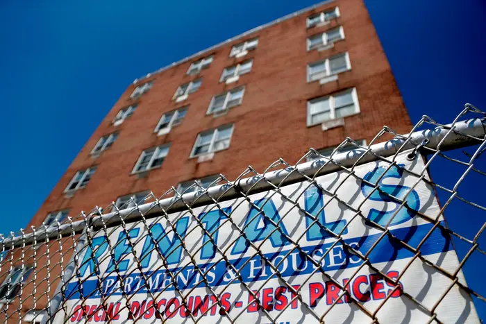 A sign hangs from the fence surrounding an apartment building in Newark, NJ.